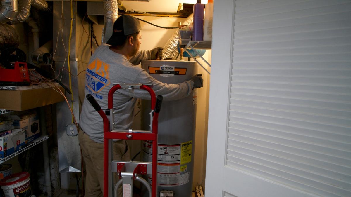 A technician at heating, cooling and plumbing company John G. Webster, removes a gas water heater from a home in Washington, DC, on August 28, 2024.