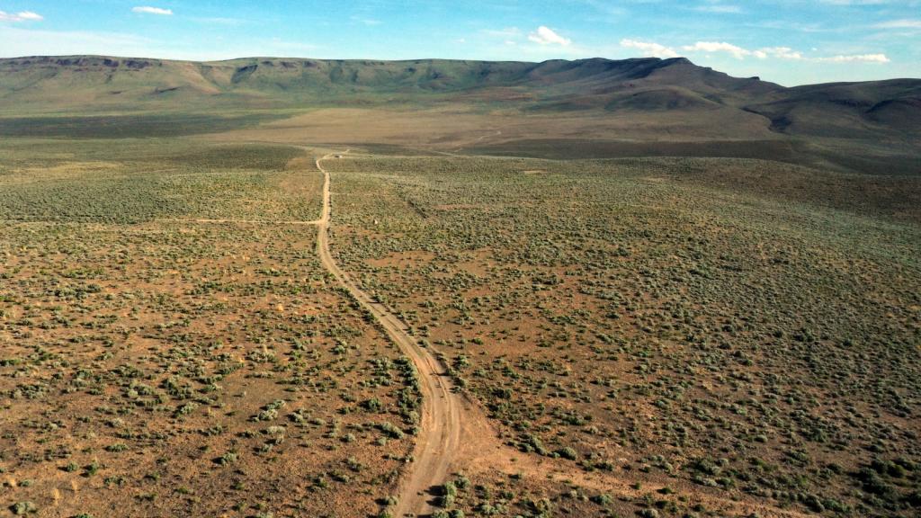 An aerial view of a barren landscape ringed with hills