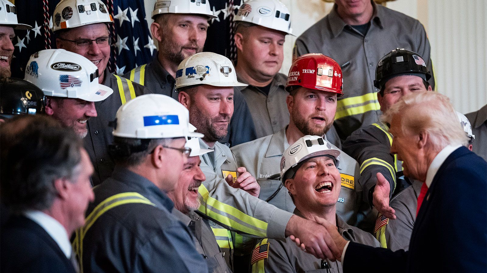 Donald Trump shaking hands with a group of coal miners