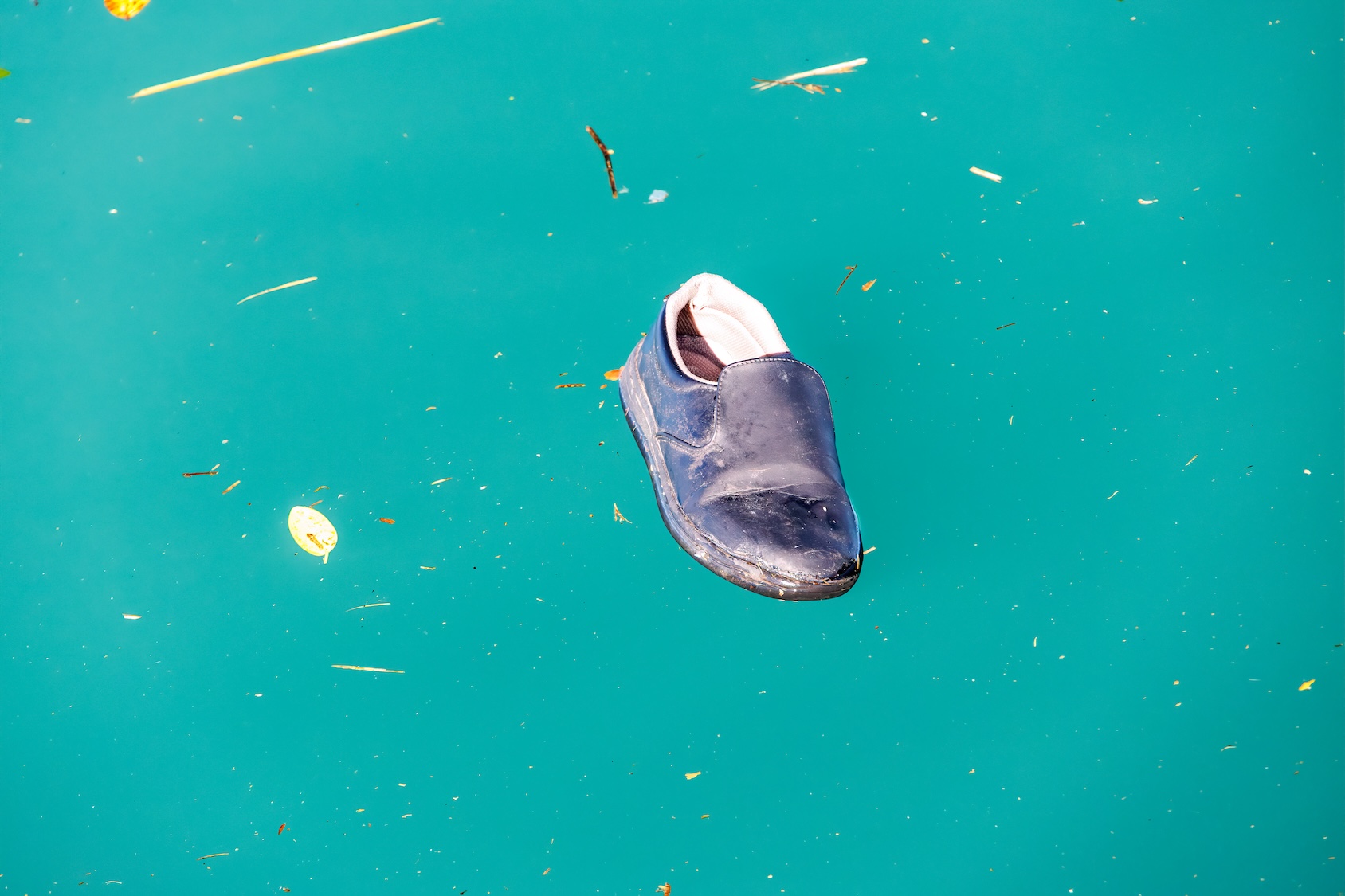 a child's shoe floats in a blue ocean