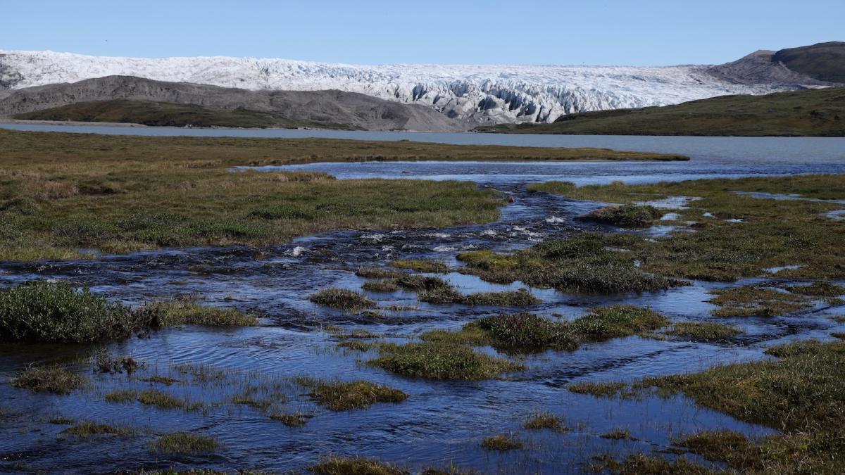 A creek running through a wetland arrives at a lake of meltwater created by the Russell Glacier in the Isunngua Highlands near Kangerlussuaq, Greenland.