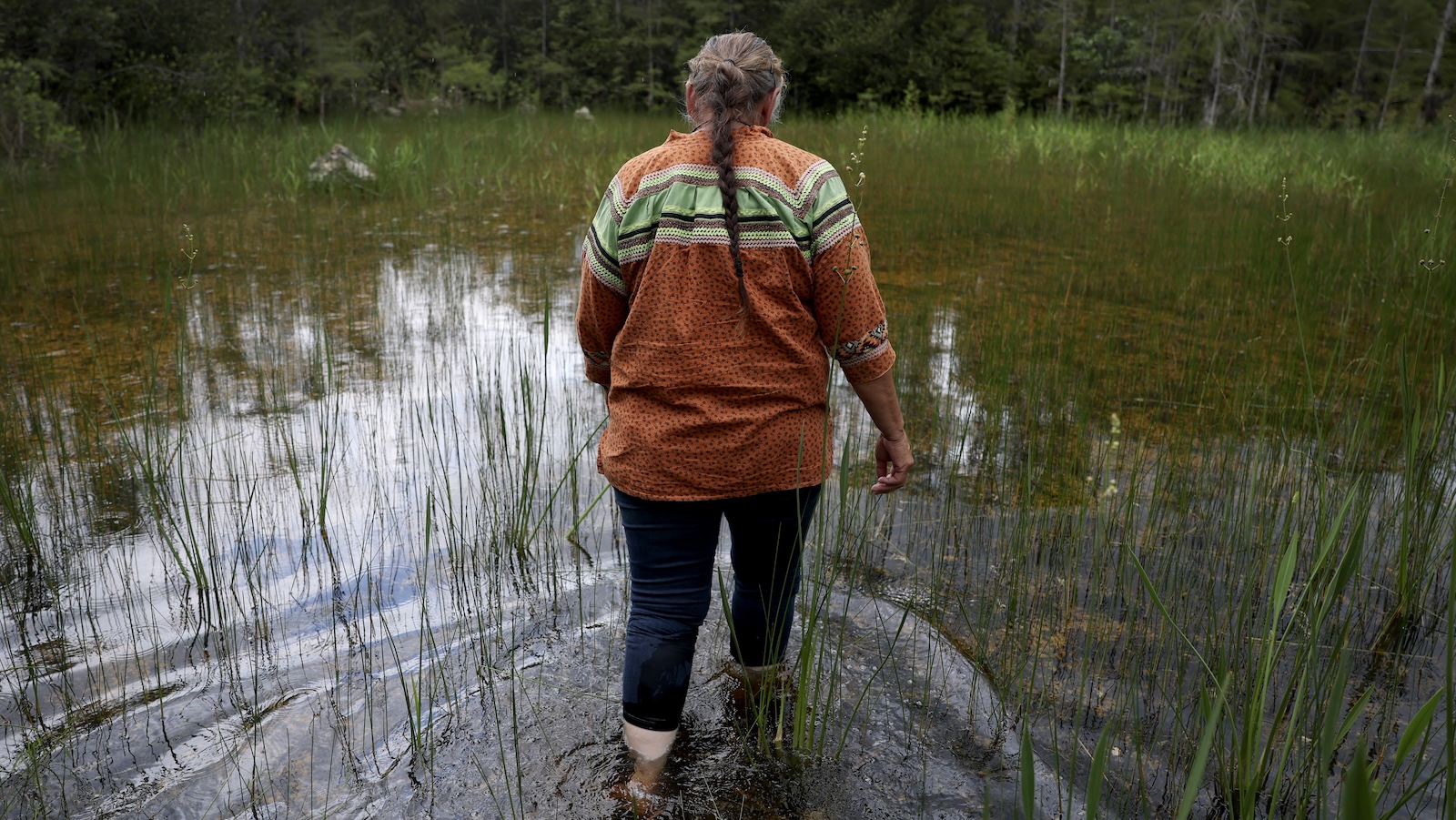 a wpman walks in shallow waters in the Everglades
