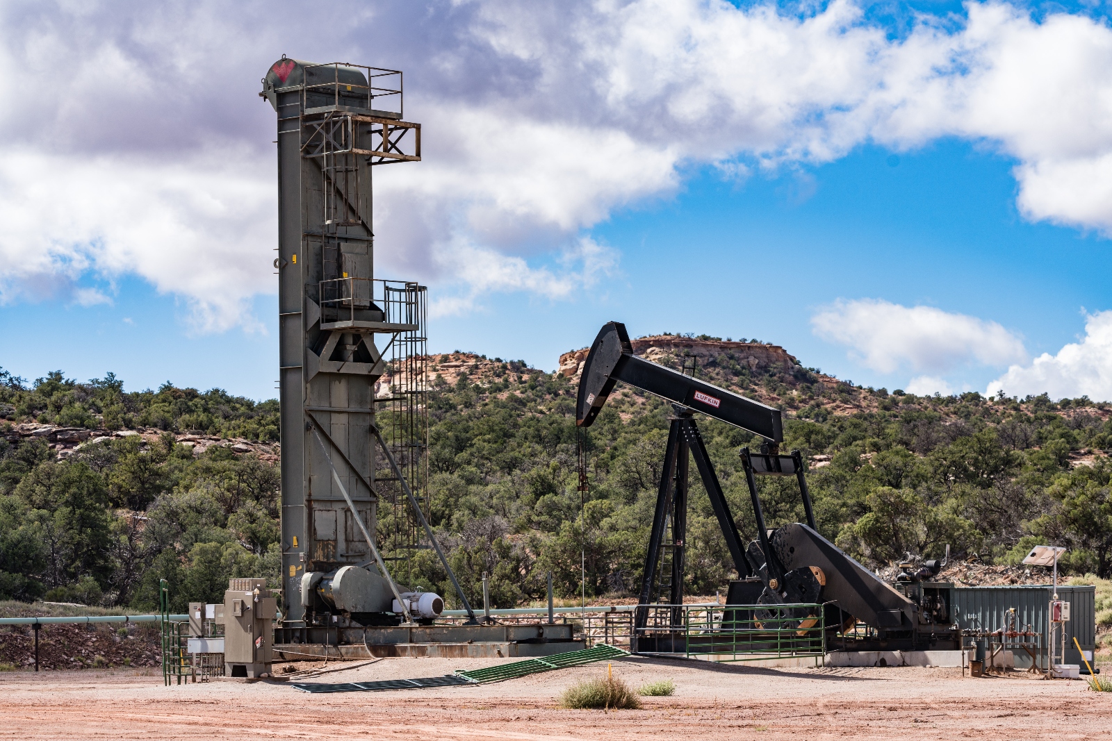 A long stroke belt pump and a traditional pump jack on adjacent oil wells in the canyon country of Utah
