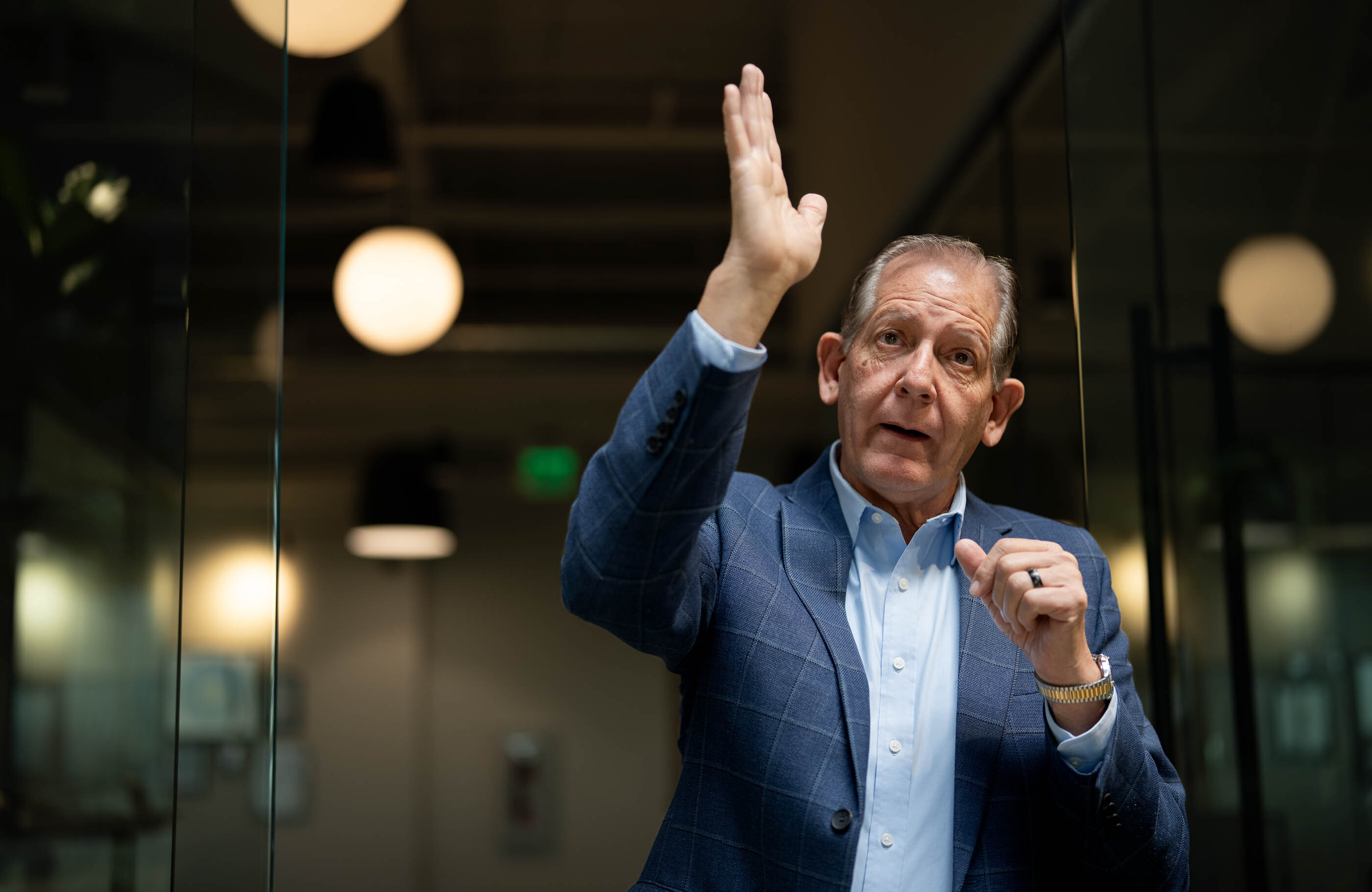 A man in a blue sportsjacket talks about a data center under construction in his office