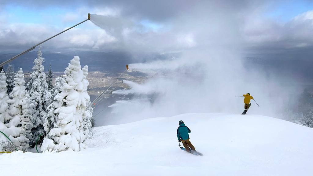 Snow guns blow snow over skiers at Sugarloaf Mountain.