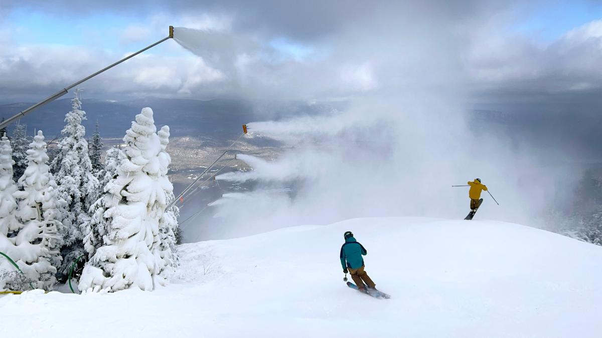 Snow guns blow snow over skiers at Sugarloaf Mountain.