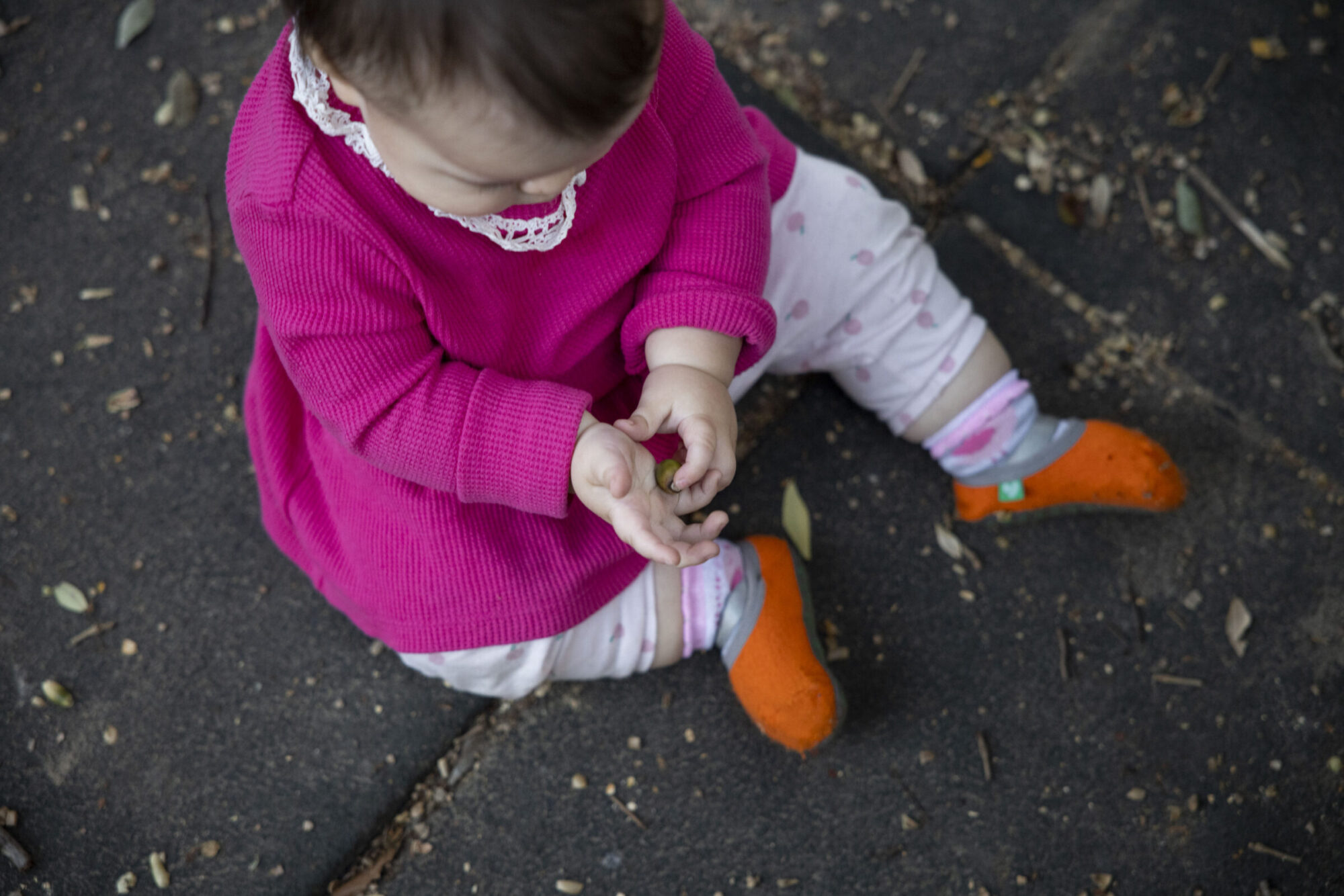 A toddler sits in the dirt