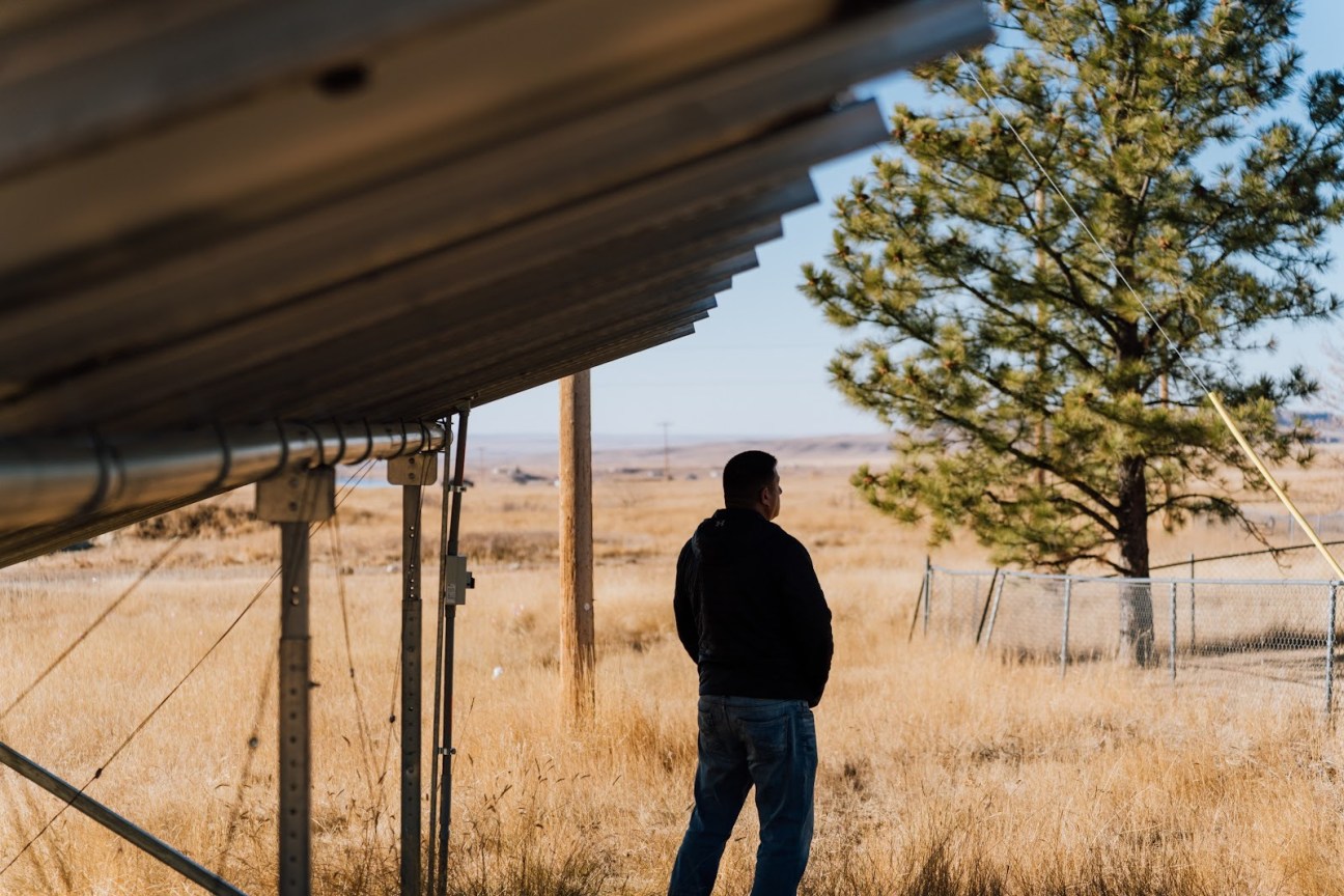 A man stands on the prairie looking at the horizon