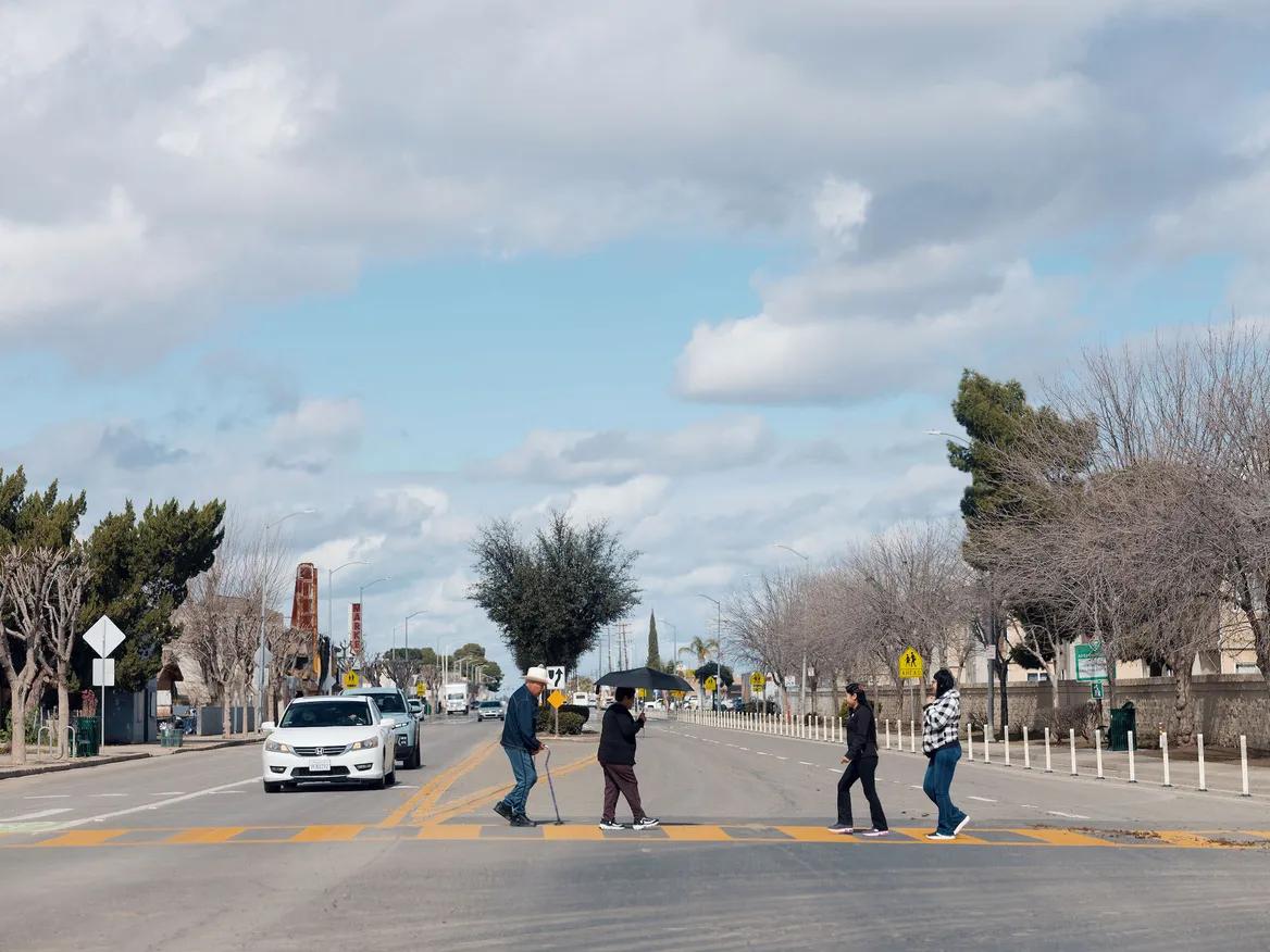 People cross a suburban street