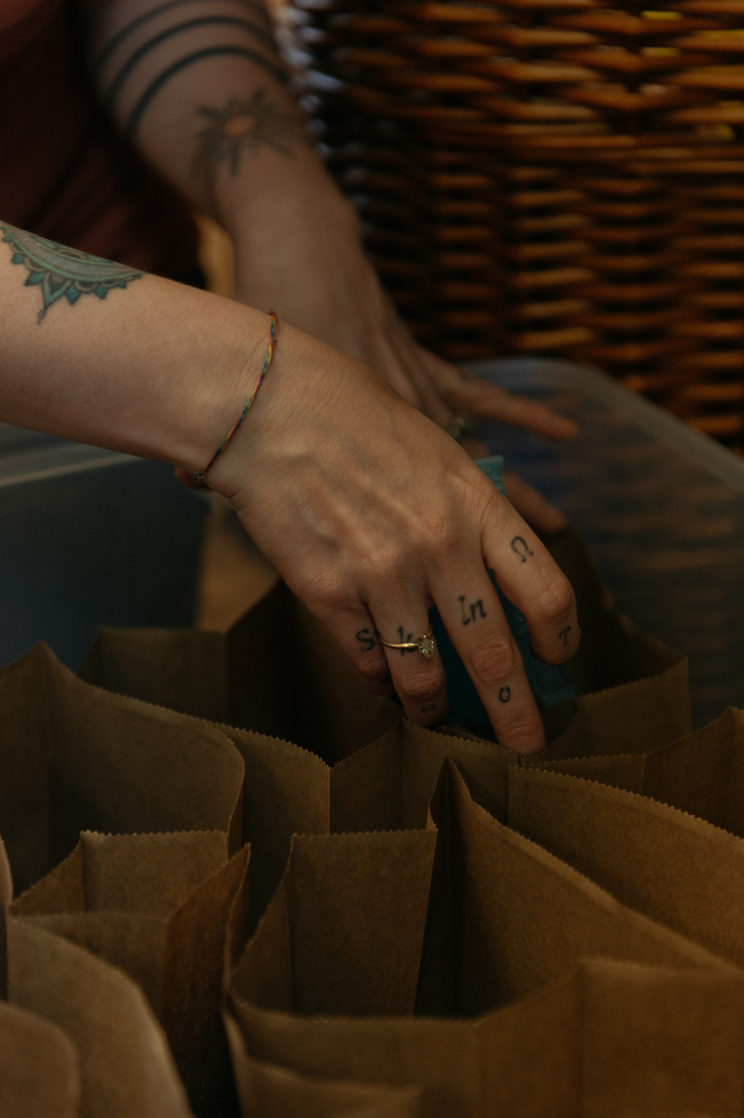 A pair of hands places supplies into paper bags.