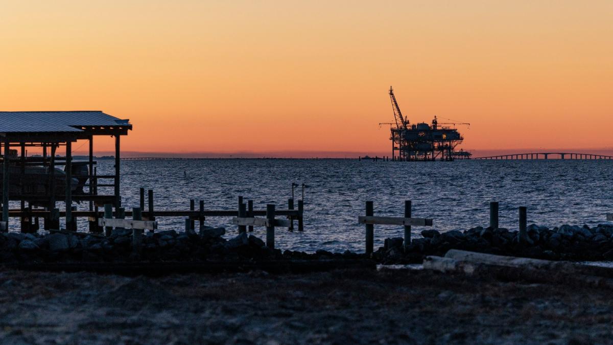 An oil drilling rig in the Gulf of Mexico seen from the shoreline at Fort Morgan, Alabama.