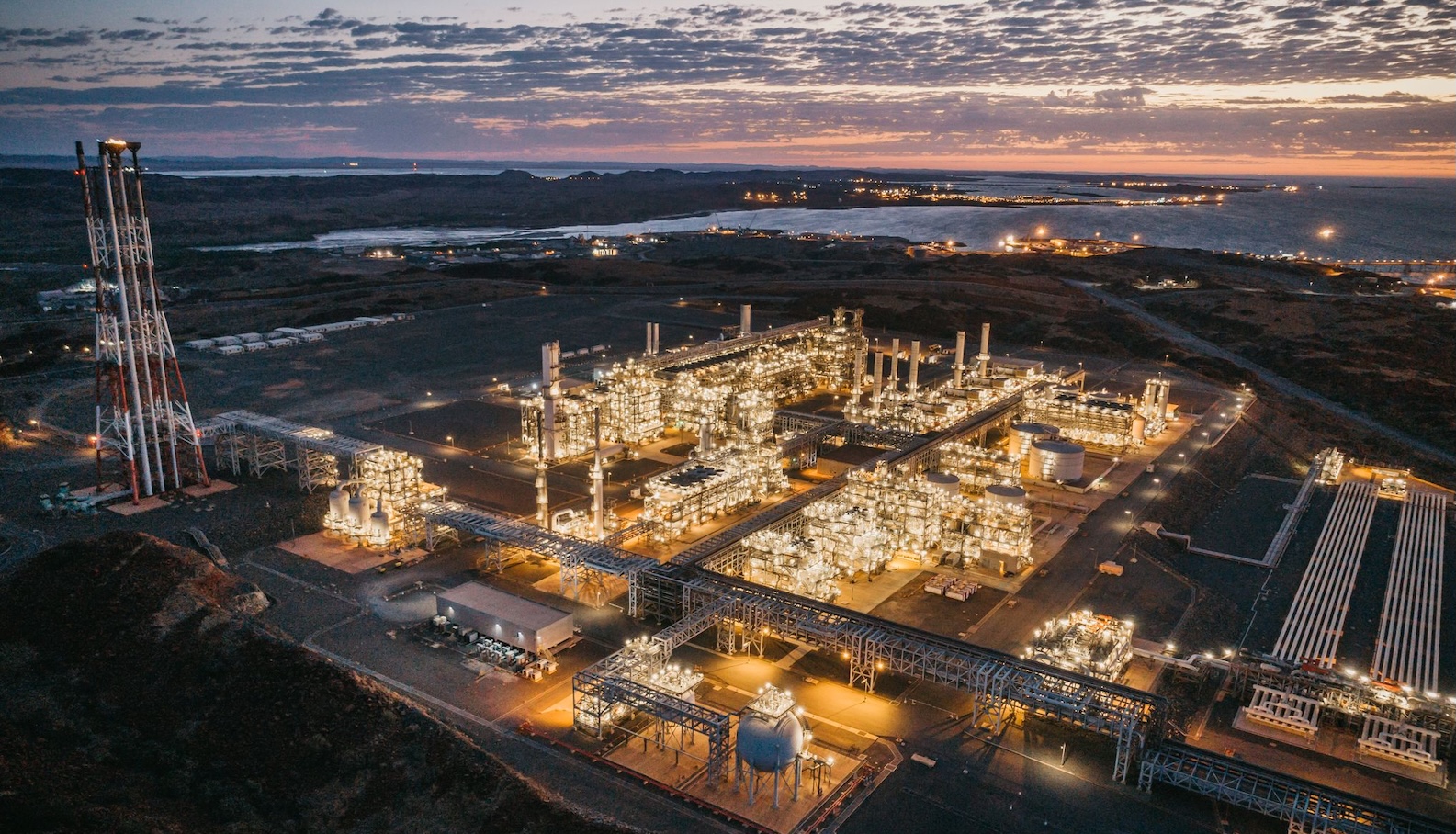 A liquid natural gas facility glows at sunset in Western Australia.
