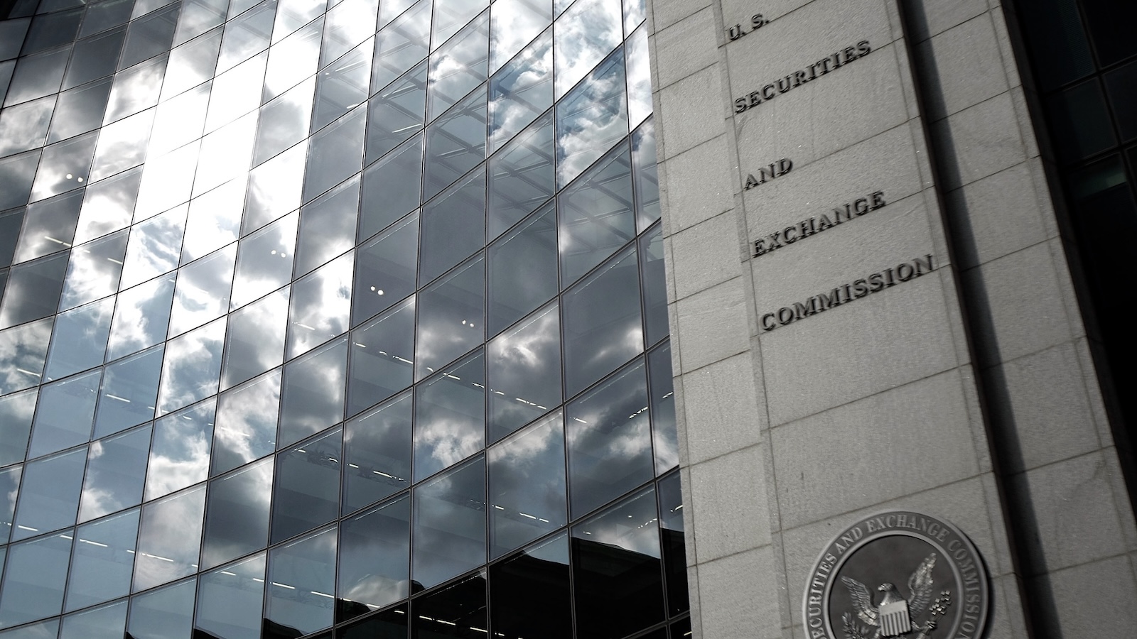 clouds reflected off windows on a building labeled securities and exchange comission