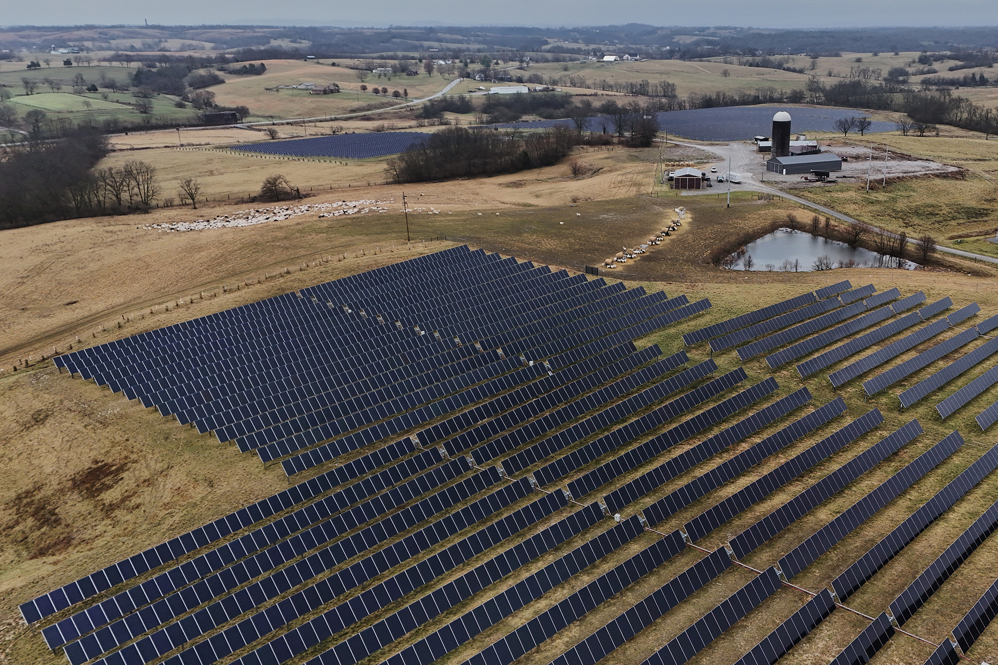 An aerial photograph of a large array of solar panels surrounded by farmland.