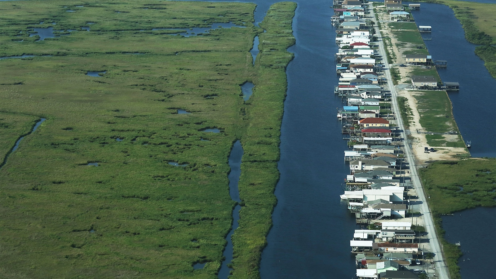 Houses sit next to deteriorating wetlands