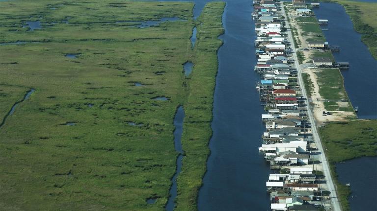 Houses sit next to deteriorating wetlands