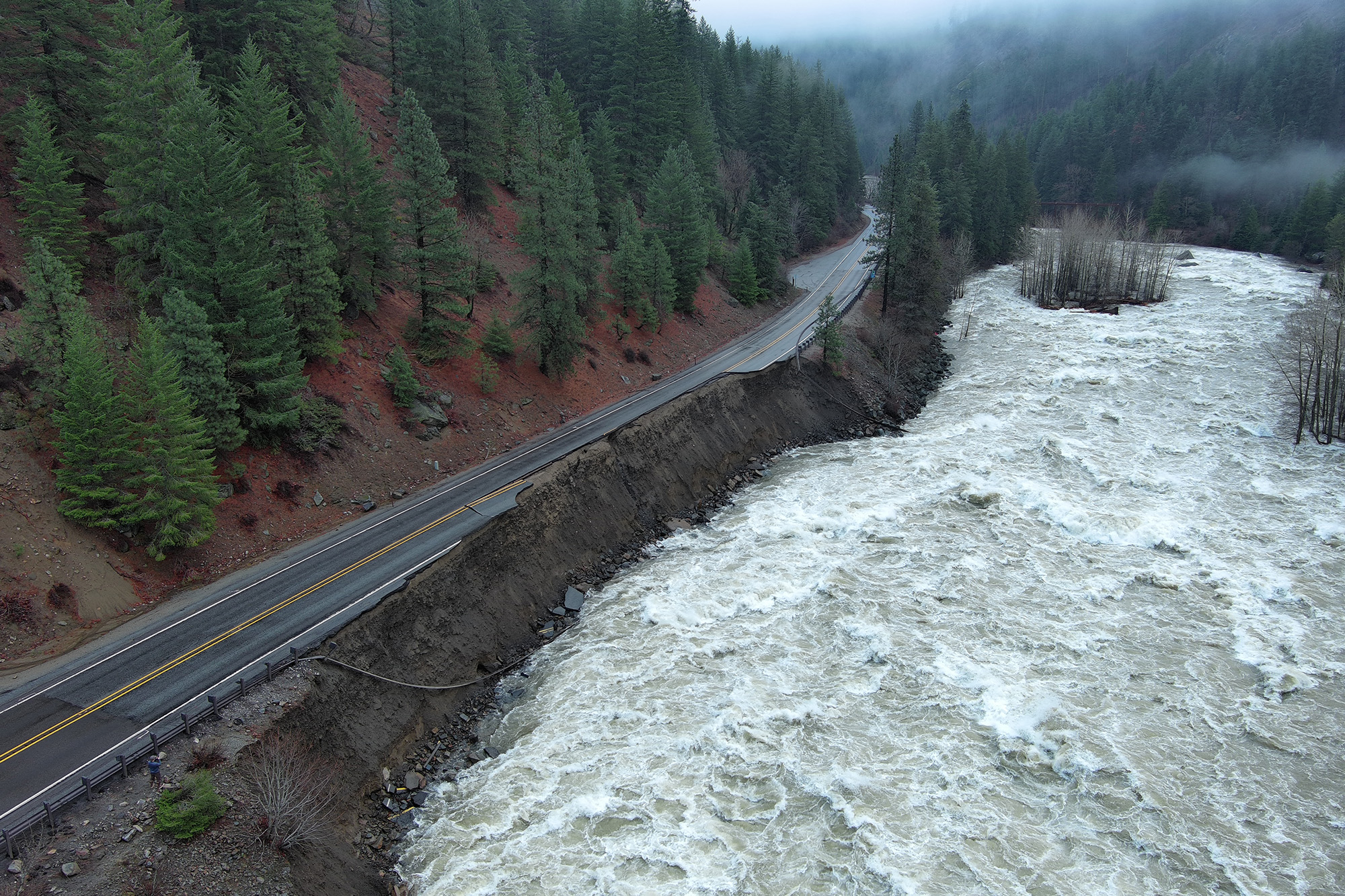 A rushing river has washed away a large section of highway.
