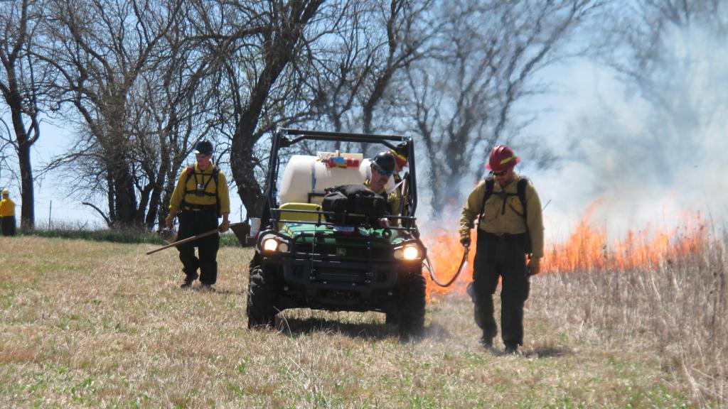 Crews walk along the fire line during a controlled burn at the Homestead National Monument in Beatrice, Neb., on Friday, April 22, 2016.
