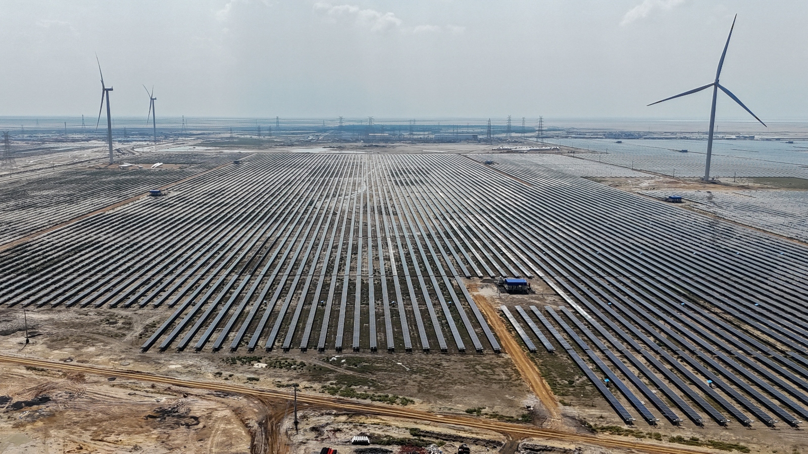 An aerial view of many solar panels under a smoggy sky