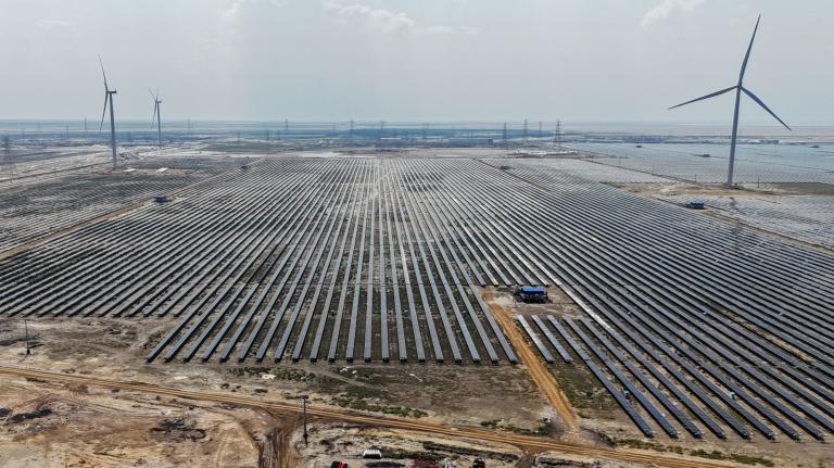 An aerial view of many solar panels under a smoggy sky