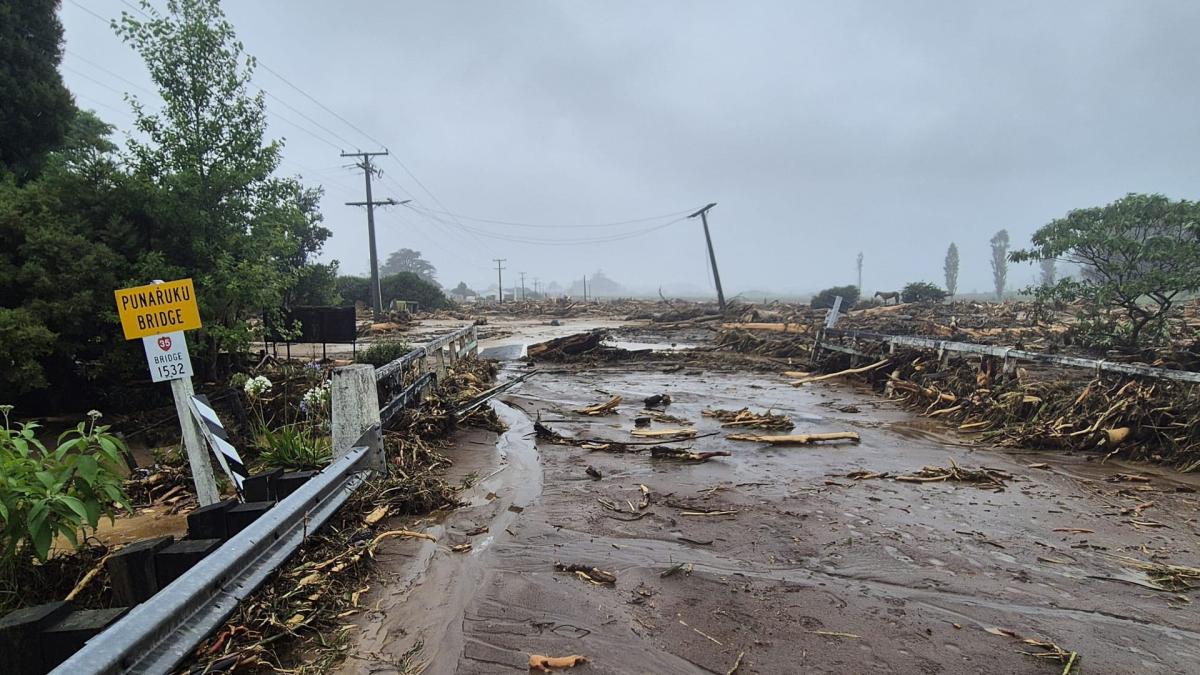 Flooded bridge with mud and tree branches strewn across