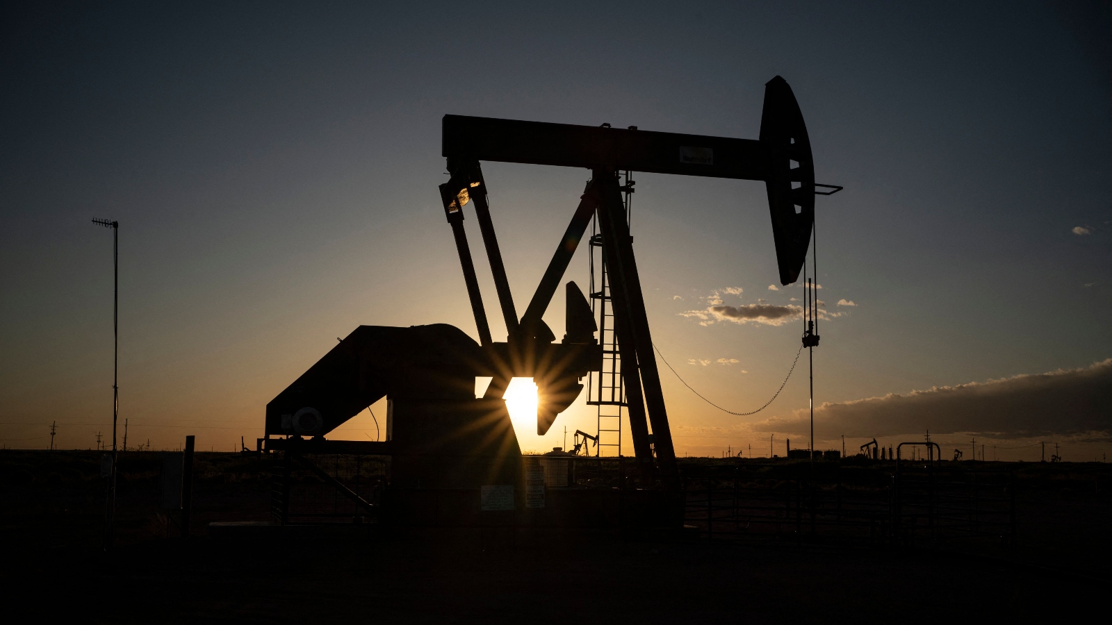 The silhouette of a pump jack at sunset