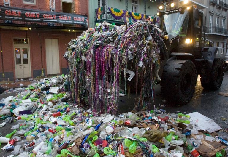 A front end loader removes trash and beads left on Bourbon Street after Mardi Gras in 2009