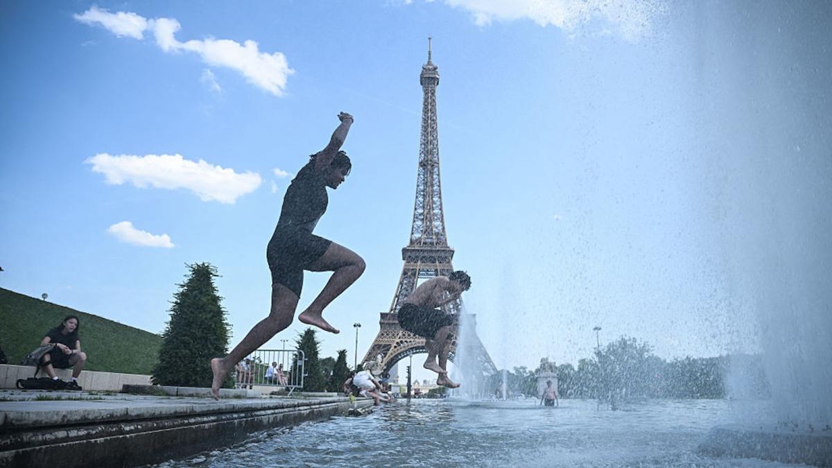 men jumping into water in front of Eiffel tower