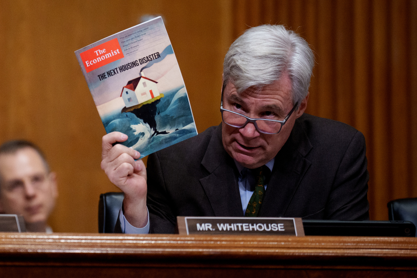Photo of Senator Whitehouse holding up an economist magazine with the headline "the next housing disaster"