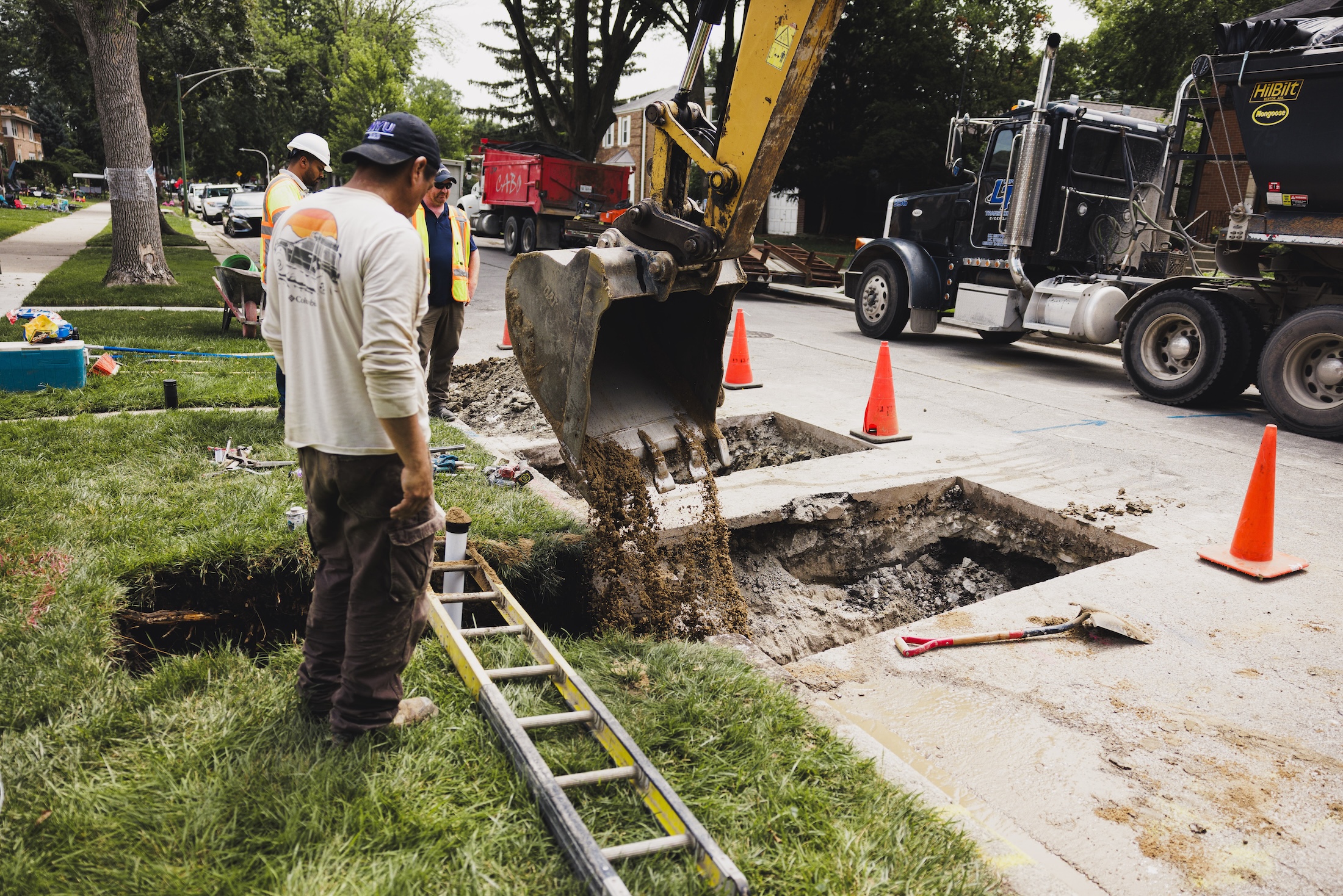 workers remove a lead service line from a residential house