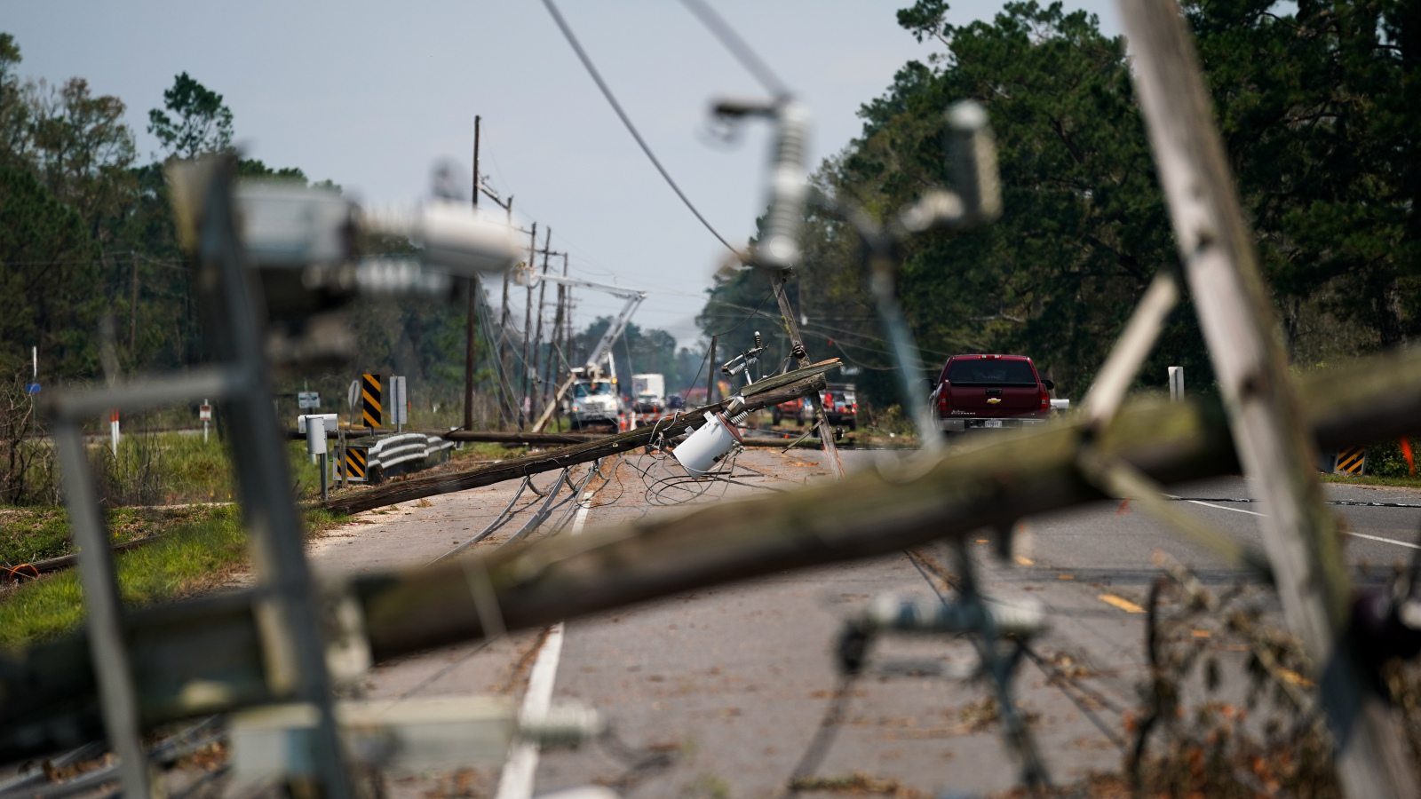 Photo of downed utility poles lying sideways across the street