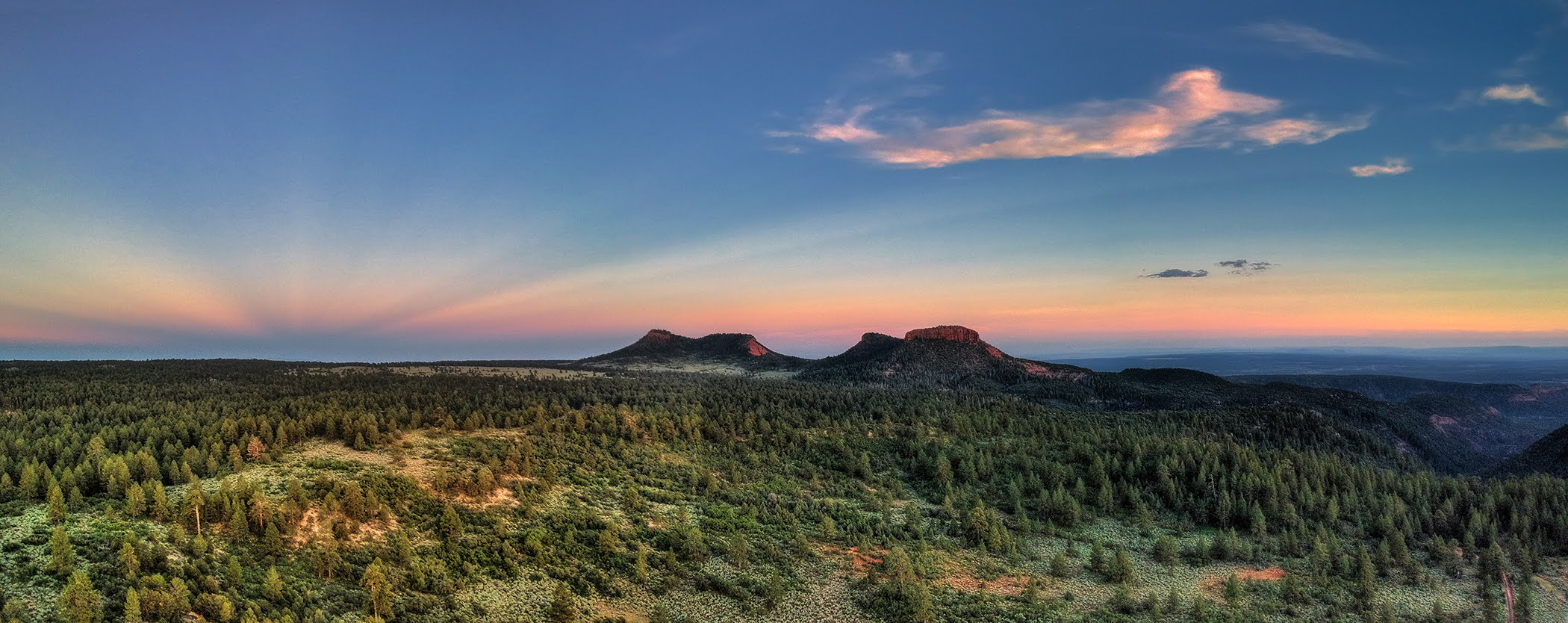 A sunset view of forest and mountains