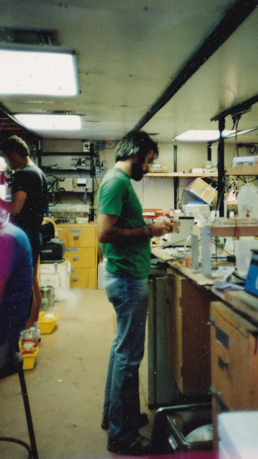 An old photo of Jon Zehr working at a lab desk.