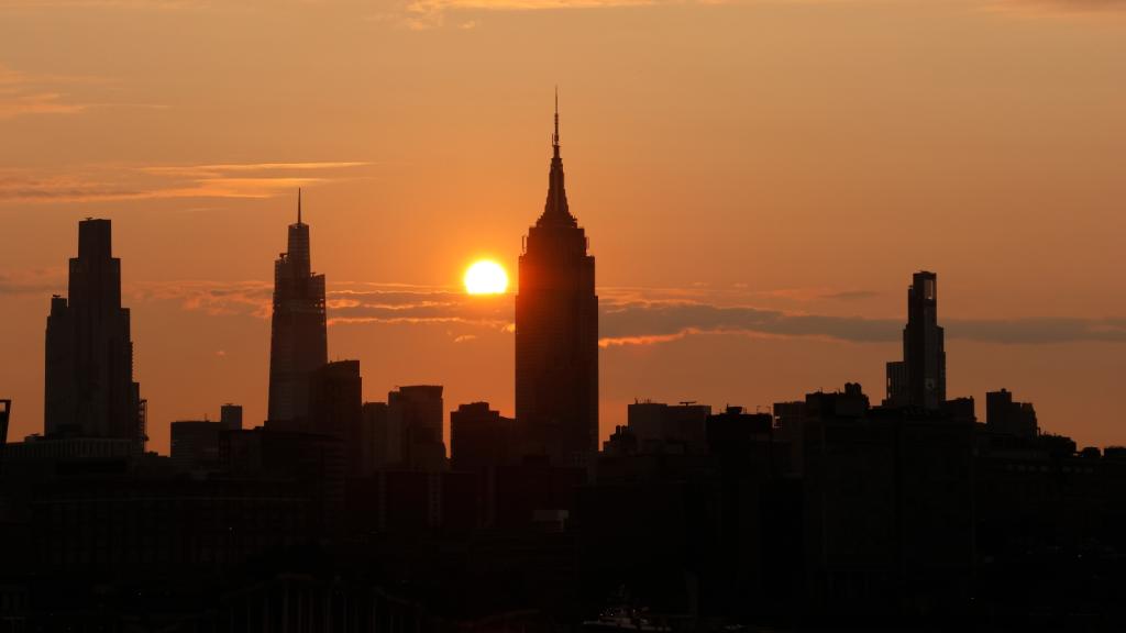 The sun behind the NYC skyline