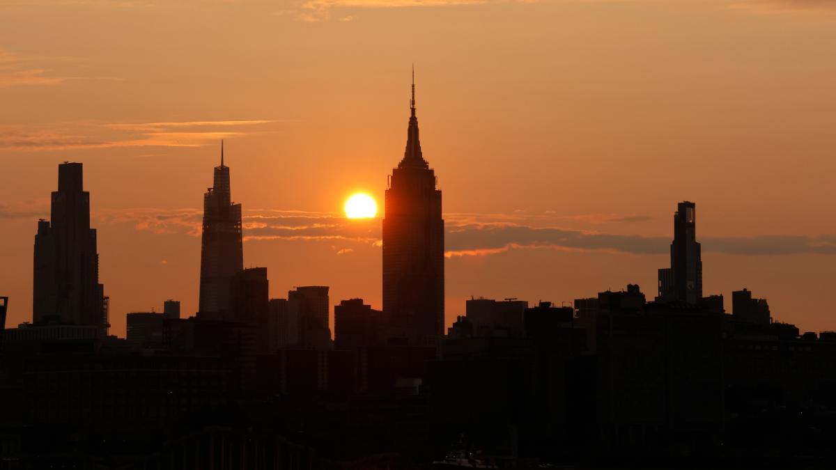 The sun behind the NYC skyline