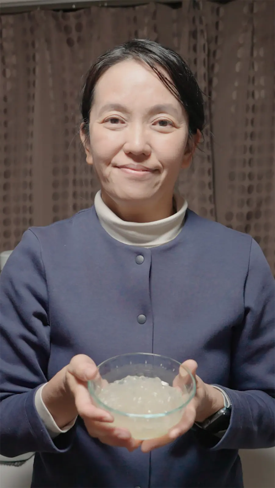 A woman holds a bowl of tokoroten noodles