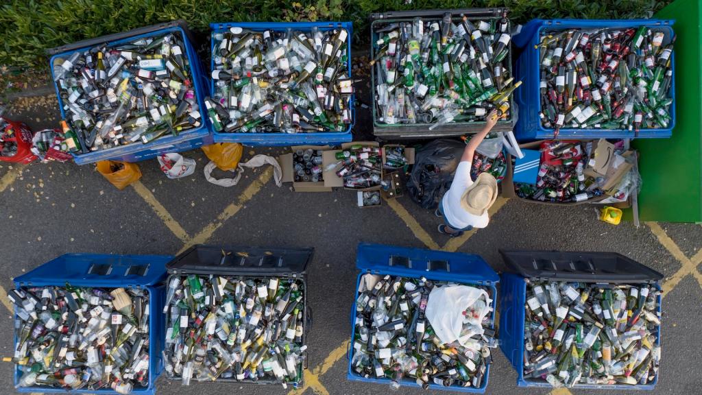 An aerial photo shows a person sorting cans and bottles for recycling.