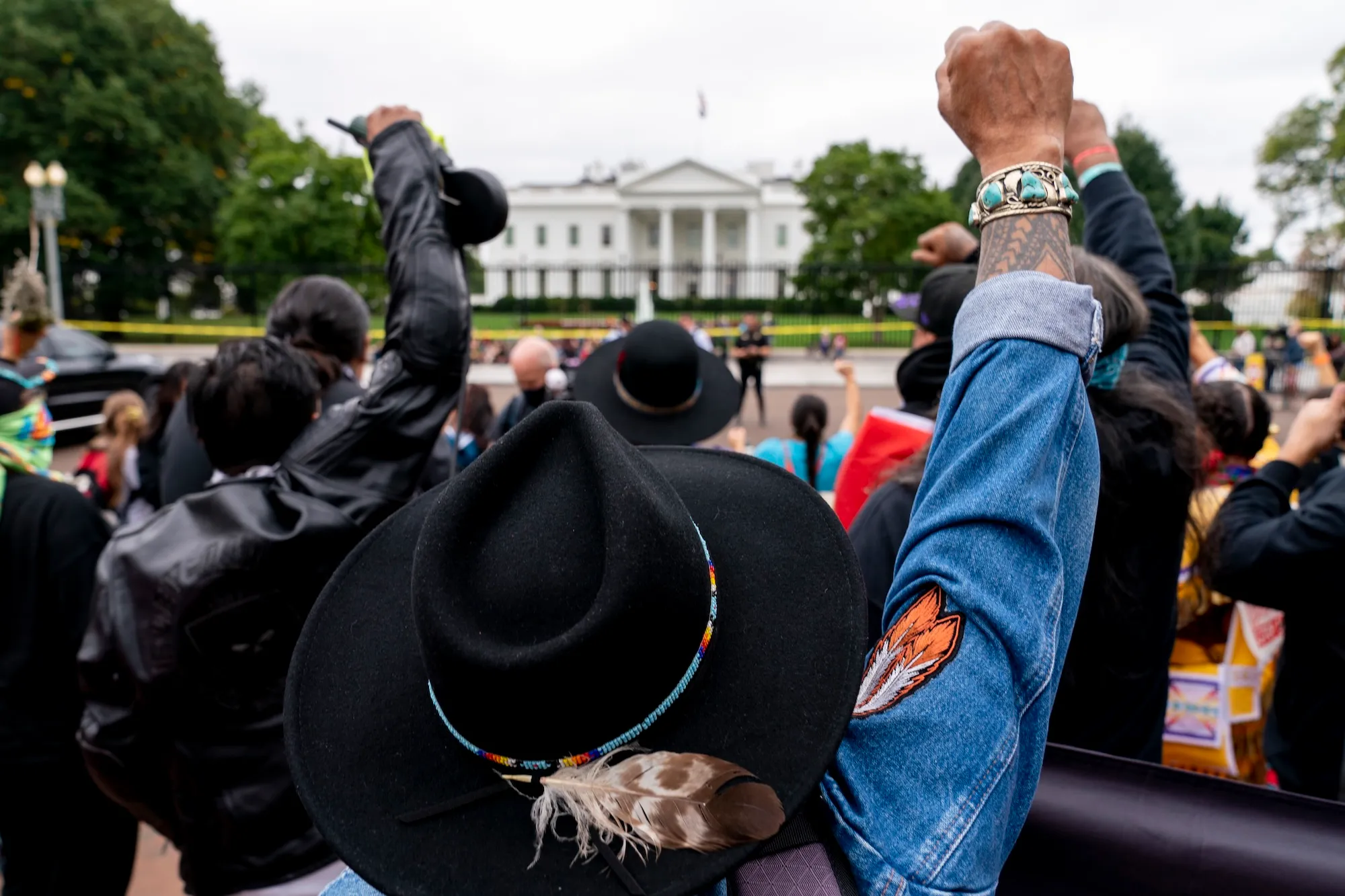 a group of people raise fists in front of the white house