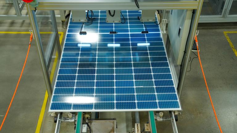blue polysilicon wafers move down the production line on the way to making solar panels