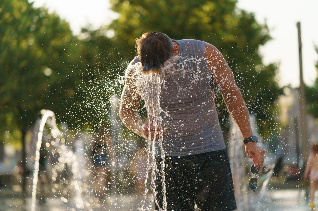 man sticks head in water fountain