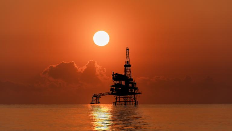 The sun sets over an offshore oil rig