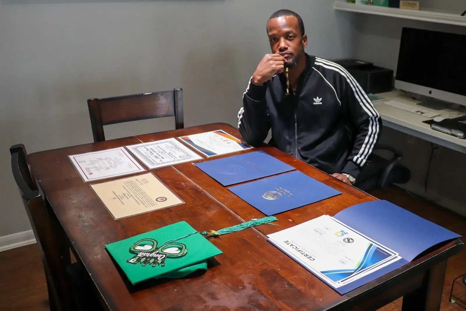 A man sits at a desk looking contempative