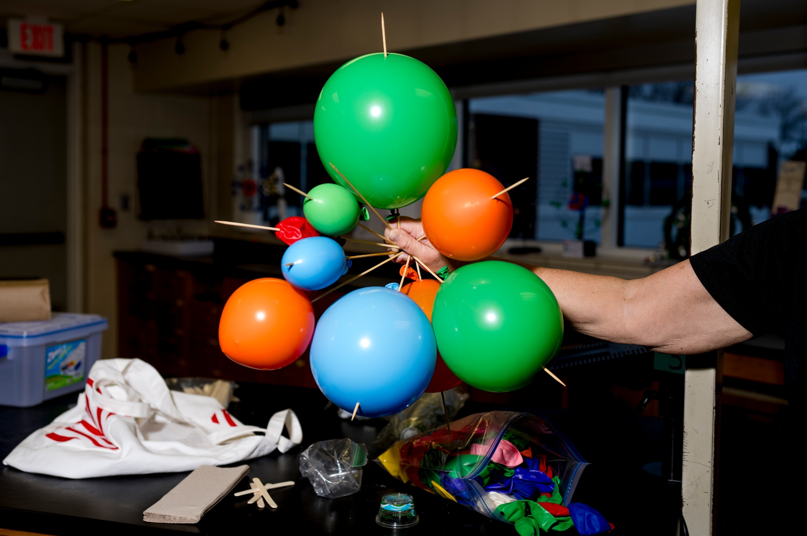 Close-up of colorful balloons linked by skewers in a classroom lab