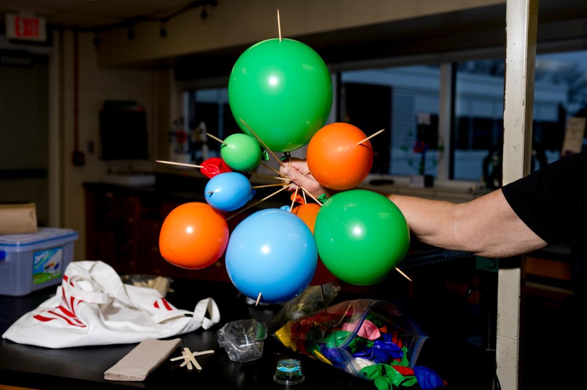 Close-up of colorful balloons linked by skewers in a classroom lab