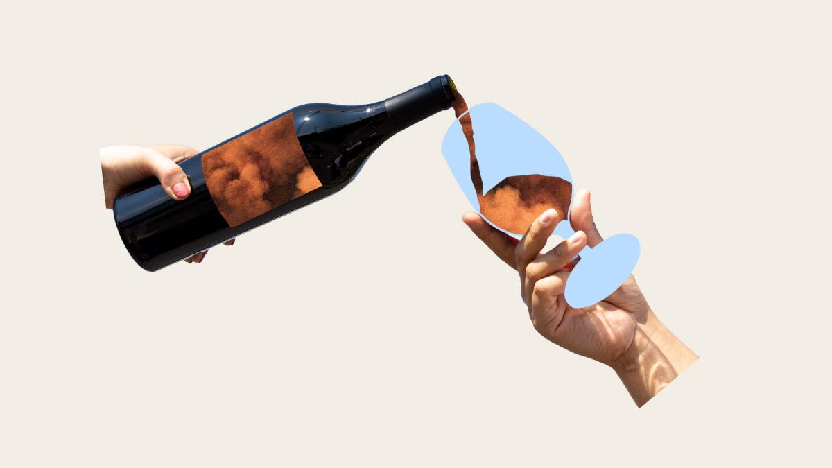 hand holding wine bottle pouring wildfire smoke into wine glass