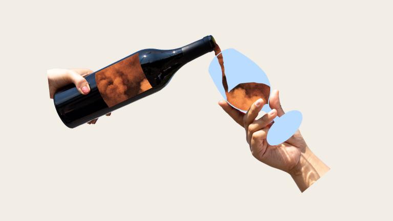 hand holding wine bottle pouring wildfire smoke into wine glass