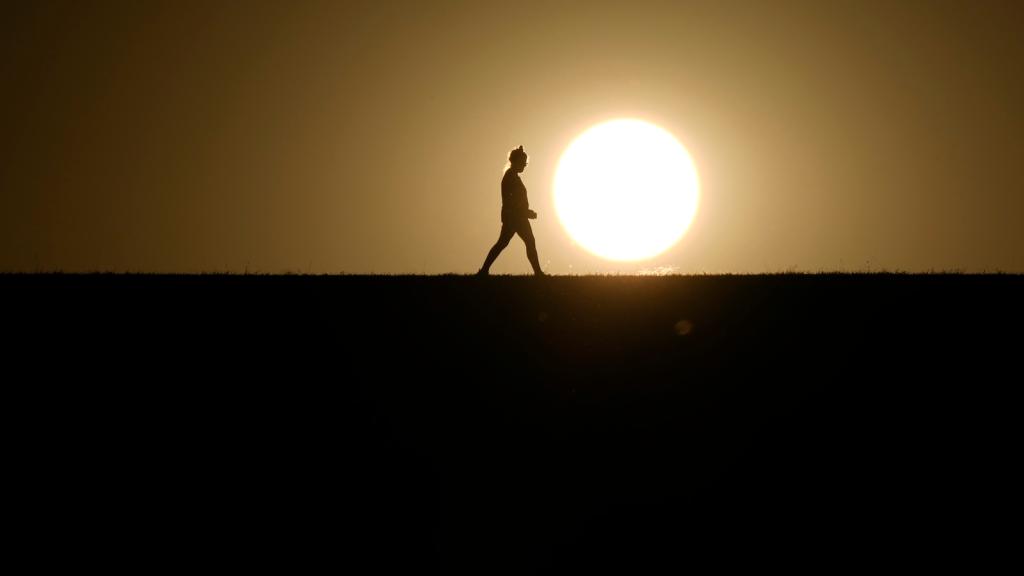 A person walks on a path during sunset on Monday, Sept. 30, 2024, in Omaha, Nebraska.
