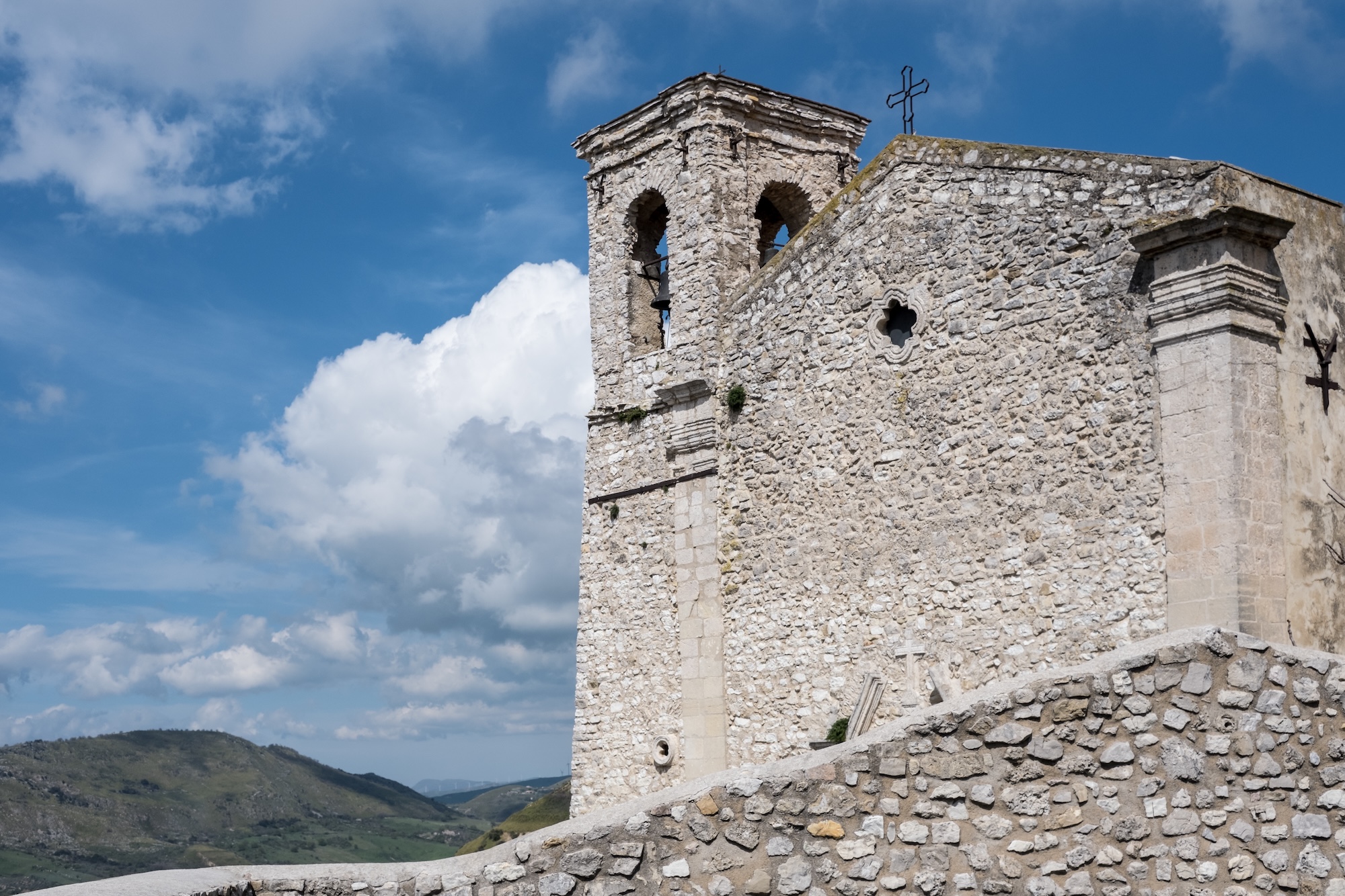 a 15th centry stone church facade against a blue sky