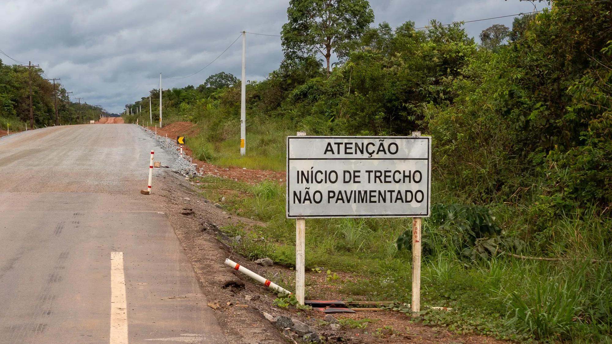 A sign in portuguese marking the start of the amazon road paving project