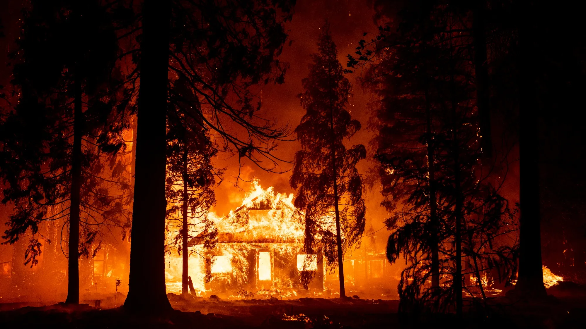 A home burns as flames from the Dixie Fire tear through the Indian Falls neighborhood of unincorporated Plumas County, California in 2021.